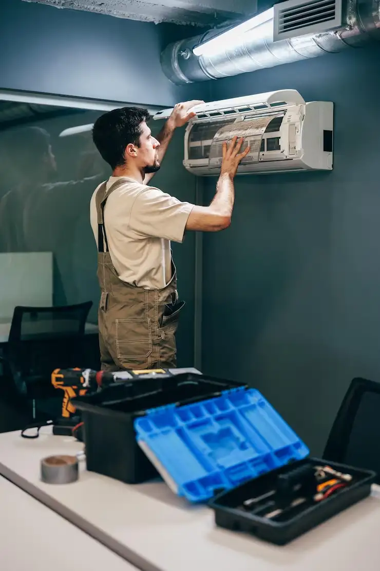 maintenance technician installs air conditioning